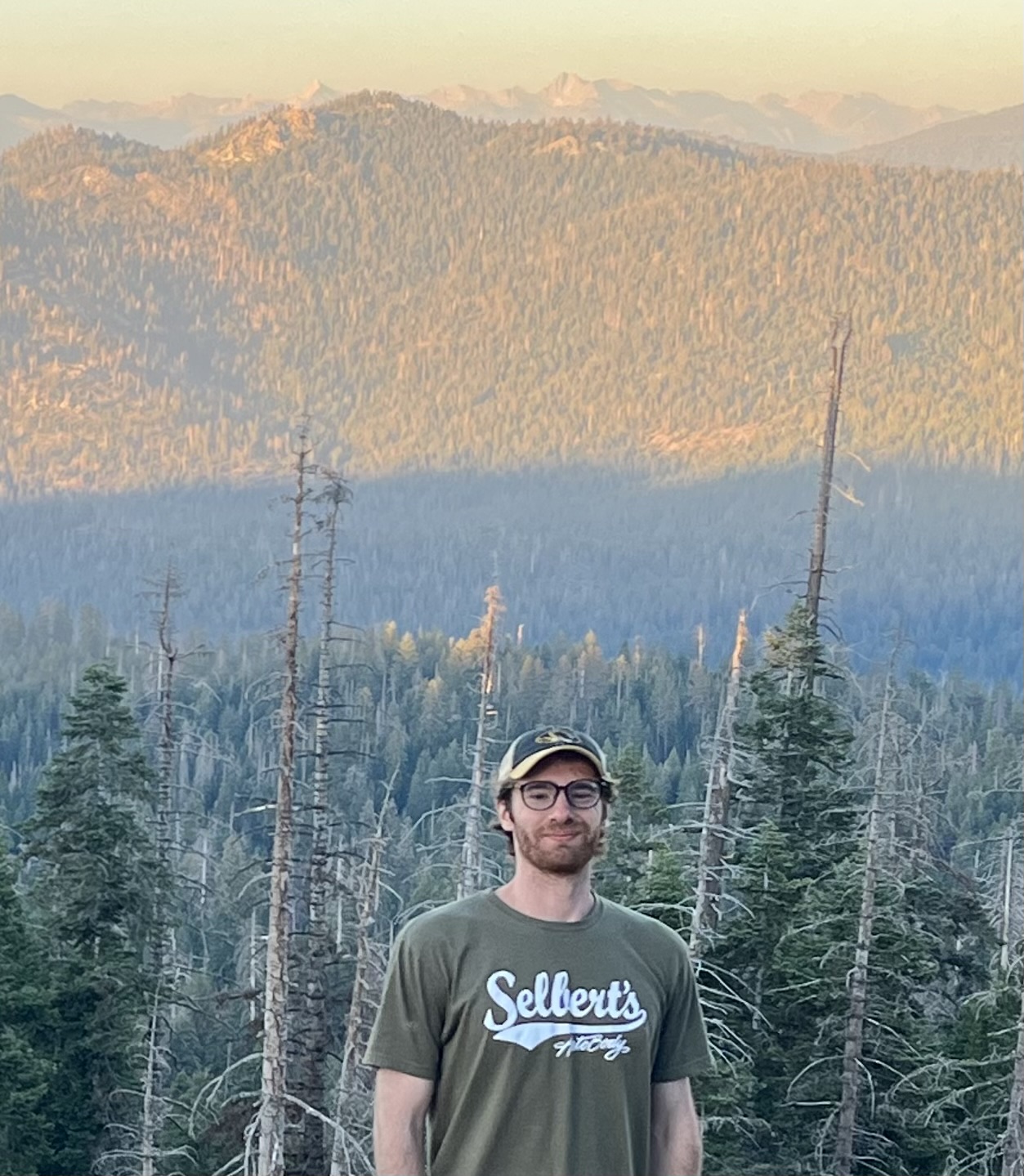 Thomas Hogancamp outdoors with forested mountains in the background